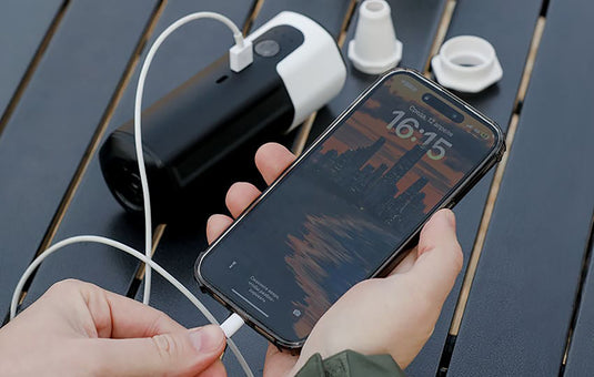 A Quest High Flow Pump portable power bank in black and white with a red collar and white top cap, shown on a solid white background.